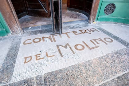 Volvieron las letras rojas al piso de la entrada principal, en la ochava. El solado se compone de pequeñas teselas de mármol. Se realizaron trabajos de limpieza, consolidación de existencias y reposición de faltantes en letras y teselas