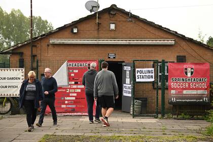 Votantes británicos en una escuela en Lees, cerca de Oldham, en el norte de Inglaterra, en las elecciones locales de mayo de 2022. (Oli SCARFF / AFP)