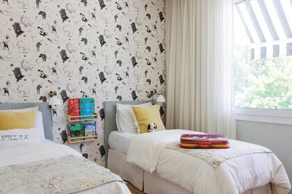 Wallpaper con motivos de animales (Picnic). Respaldos de madera con funda de lino belga color celadón. Funda de lienzo de algodón crudo (Zara Home). Mantas de lino estampado (ABC Home). Estantes para apoyar libros (Ikea).