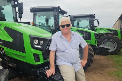 Walter Berger posa frente a un tractor de la firma alemana