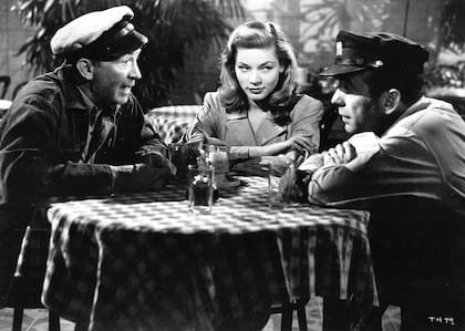 Walter Brennan (uno de los legendarios actores secundarios del cine clásico) junto a Lauren Bacall y Humphrey Bogart en el salón del hotel donde transcurre la acción en Tener y no tener.