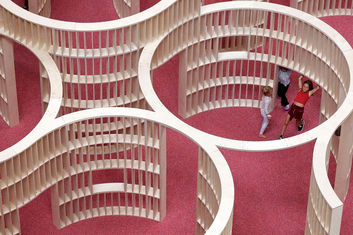 WASHINGTON, DC - 9 de julio de 2026: Niños disfrutan del laberinto de paredes onduladas de la nueva instalación del Museo Nacional de la Construcción, THE PLAYGROUND, en Washington, DC. Diseñada por el estudio neoyorquino Snarkitecture, es la instalación interior más grande del museo hasta la fecha, con nueve zonas de juego construidas con materiales de construcción como madera contrachapada y andamios. THE PLAYGROUND está abierta al público todos los días hasta el 30 de agosto de 2026. Alex Wong/Getty Images/AFP (Foto de ALEX WONG / GETTY IMAGES NORTH AMERICA / Getty Images vía AFP)