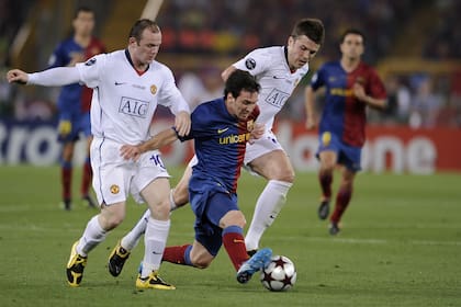 Wayne Rooney, goleador histórico de la selección inglesa, y el defensor Patrick Carrick, encierran a Messi en un partido del United contra Barcelona