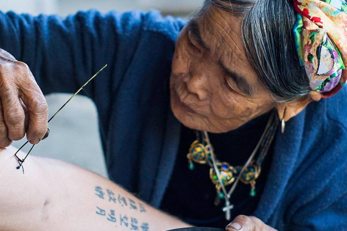 La tatuadora posa Whang Do posa para la foto dejándo a la vista los tatuajes de sus brazos y pecho.
