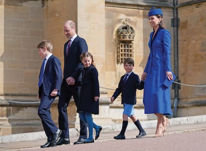 William llevó de la mano a George y Charlotte y Kate, a Louis. La princesa de Gales impactó con un coatdress con cuello de terciopelo de Catherine Walker, que accesorizó con stilettos Gianvito Rossi, clutch Emmy London, sombrero Lock & Co, pendientes de Carousel Jewels y su icónico anillo de compromiso que perteneció a Diana de Gales.