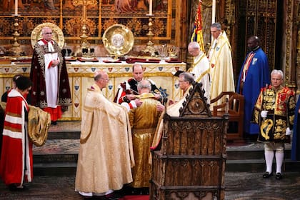 William también ayudó a Carlos III con su túnica dorada real, conocida como el manto, antes de la coronación.