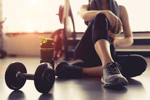 Woman exercise workout in gym fitness breaking relax holding apple fruit after training sport with dumbbell and protein shake bottle healthy lifestyle bodybuilding, Athlete builder muscles lifestyle.