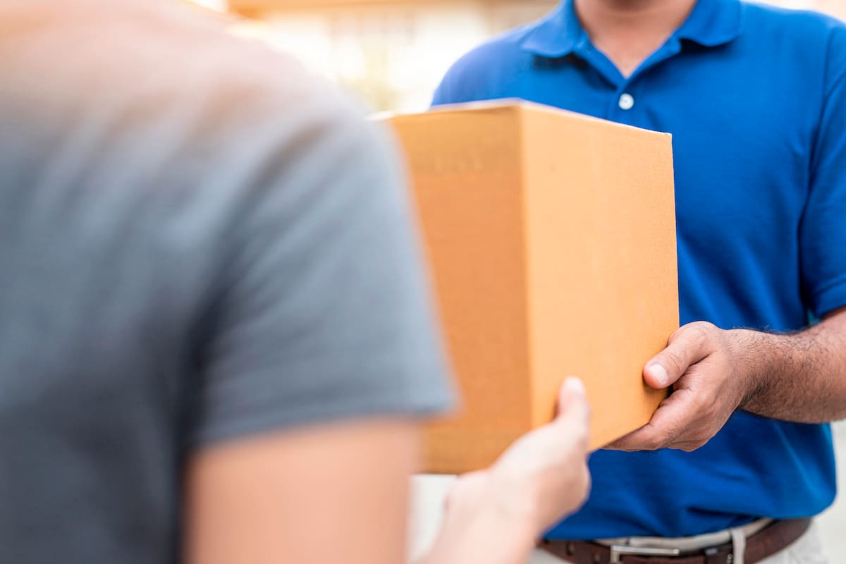 Woman hand accepting a delivery boxes of paper containers from deliveryman,Delivery concept.