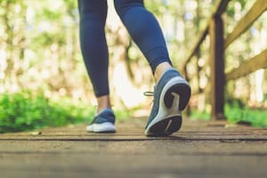 Woman runner feet walking in nature. Close up on shoes. Healthy lifestyle fitness concept.