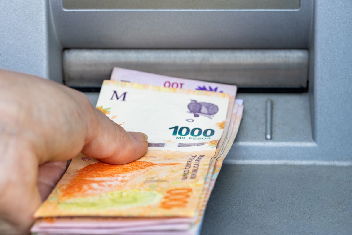 Woman takes Argentine money from ATM, Thousand pesos banknote, Highest denomination, Financial concept related to inflation and bankruptcy of the country
