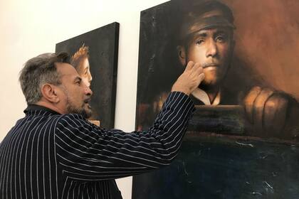 Zanetti corrige a último momento una pintura, ya colgada en la galería