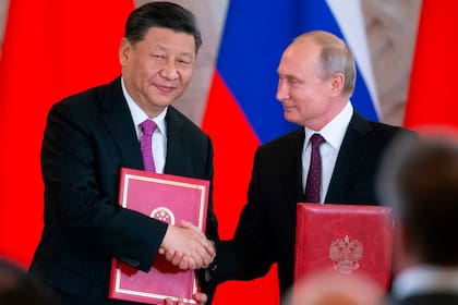 Xi Jinping y Vladimir Putin intercambian documentos durante una cumbre en el Kremlin en 2019