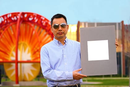 Xiulin Ruan, profesor de ingeniería mecánica de la Universidad Purdue, posa con una muestra de la pintura más blanca creada a la fecha