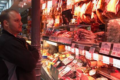 Un comprador aguarda para hacer su pedido en el Museo del jamón, en el centro de Madrid