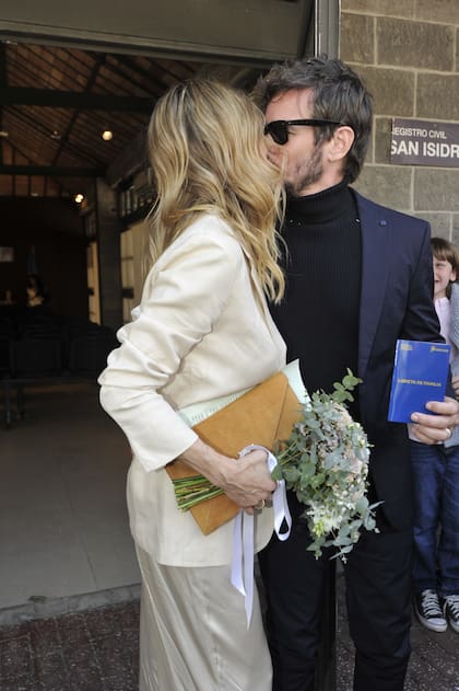 Ya fuera del registro civil, la pareja volvió a besarse mientras sostenía la libreta. Su historia comenzó en 2020 con un mensaje de Ortega por Instagram