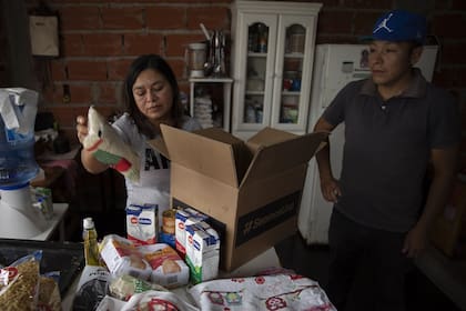 Yeny y José, vecinos de José C. Paz, al recibir la caja de alimentos; los dos se quedaron sin trabajo
