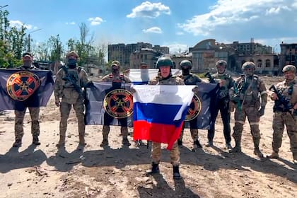 Yevgeny Prigozhin, jefe del grupo  Wagner sostiene una bandera nacional rusa delante de sus soldados en Bakhmut, Ucrania.