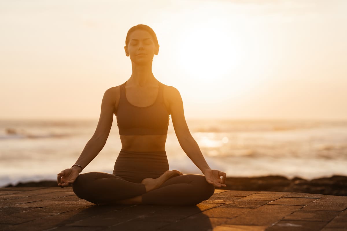 Yoga at sunset on the beach. woman performing asanas and enjoying life on the ocean. Bali Indonesia.