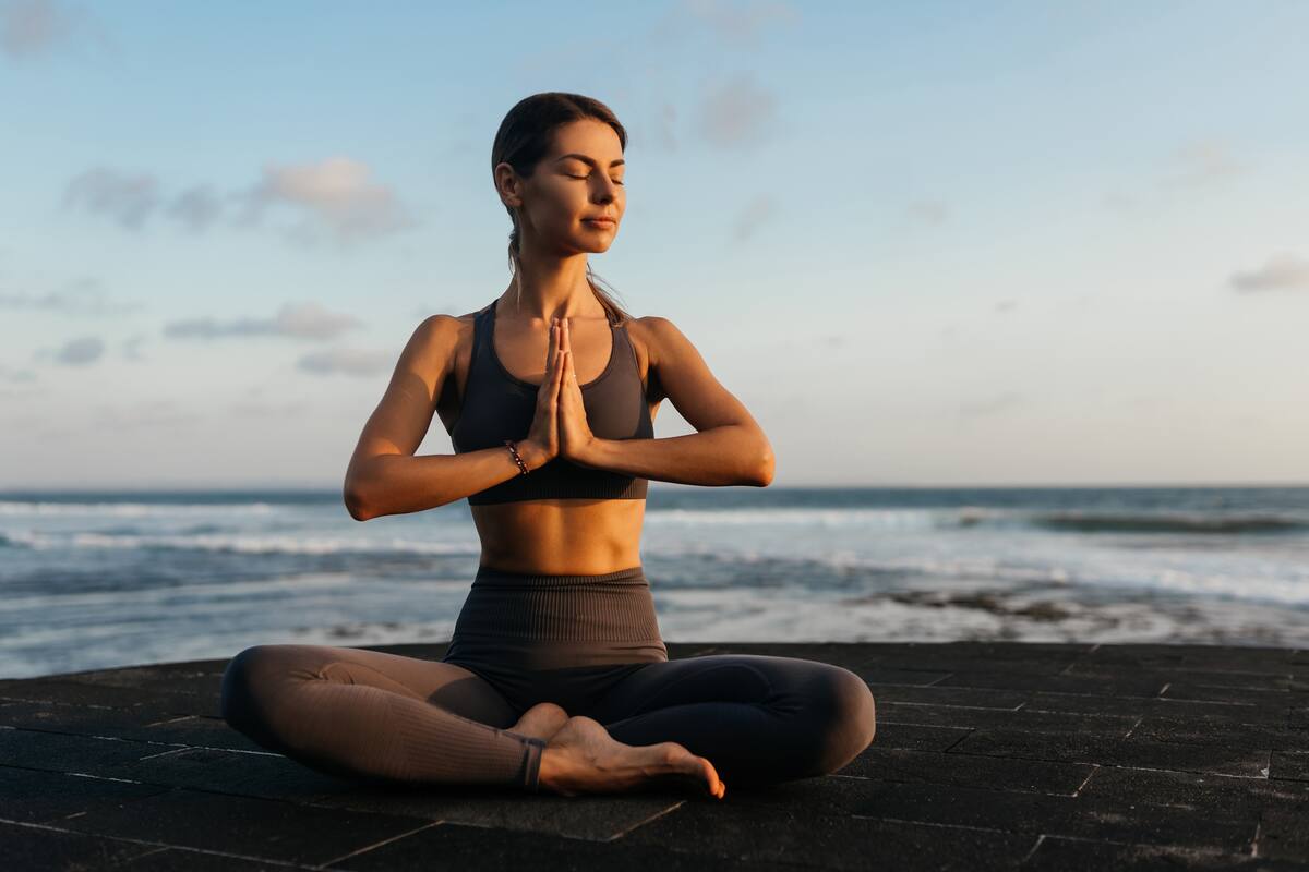young beautiful woman meditation on beach. Bali Indonesia.