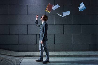 young business man walking out from office parking and throwing away paperworks. Horizontal shape, side view, copy space