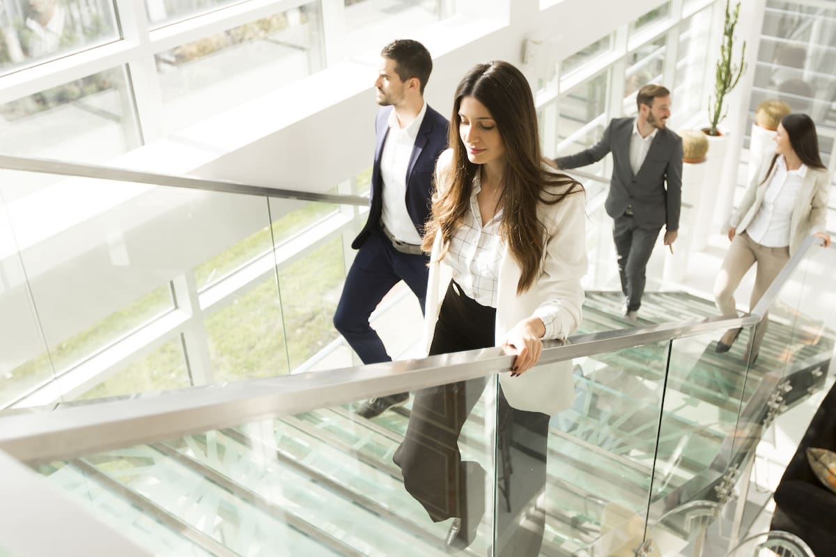 Young business people climb the stairs in the office building