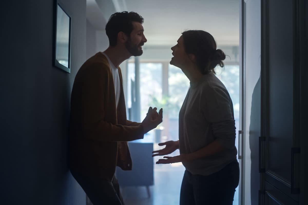 Young Couple Arguing and Fighting. Domestic Violence and Emotional abuse Scene, Stressed Woman and aggressive Man Screaming at Each other in the Dark Hallway of Apartment. Dramatic Scene