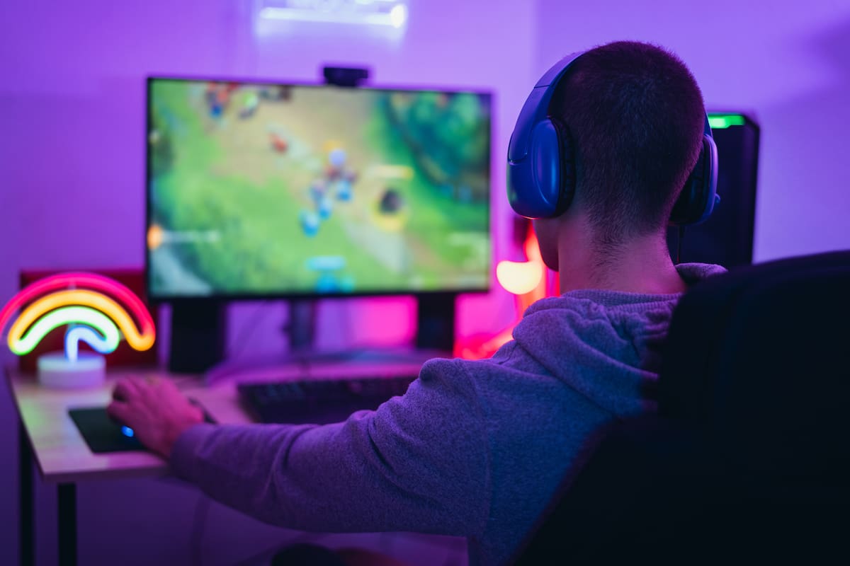 Young gamer playing online video games while streaming on social media - Youth people addicted to new technology game