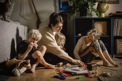 Young mother with children sitting in a community garden on a table
