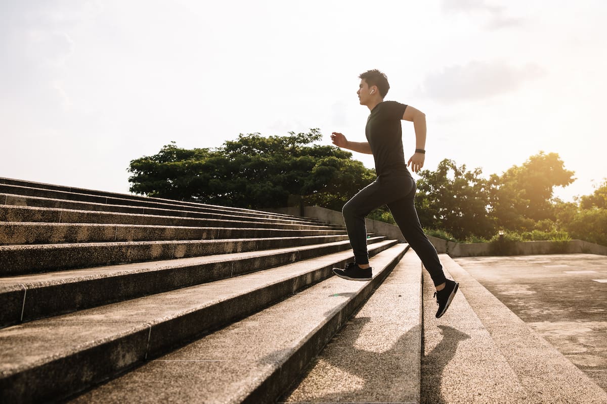 Young sport man running upstairs on city stairs