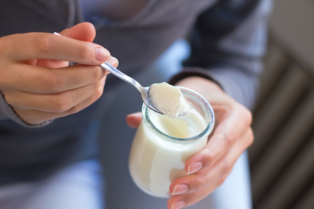 young woman at home eating yogurt