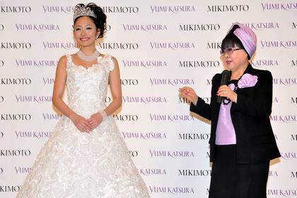 La diseñadora japonesa Yumi Katsura junto a la patinadora Miki Ando, quien luce el vestido decorado con 13.262 perlas