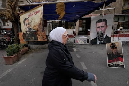 Zapatos colgados frente a retratos del depuesto presidente sirio Bashar Assad en Damasco