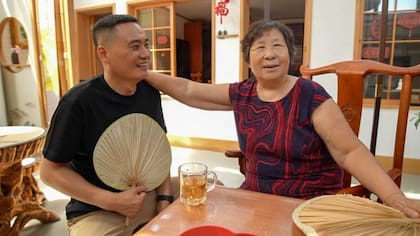 Zheng Ruizhi, de 75 años, comparte un momento distendido con Wang Yingwei durante una visita a su domicilio