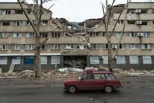 Se ve un automóvil pasar frente a los restos de un hotel alcanzado por un misil, en el centro de la ciudad de Mykolaiv, Ucrania, 2022-04-08