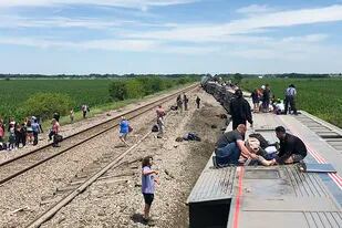 En esta foto proveída por Dax McDonald, un tren de pasajeros yace de lado después de descarrilarse cerca de Mendon, Missouri, el lunes 27 de junio de 2022. (Dax McDonald vía AP)