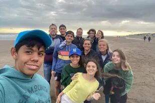 Tincho (al frente, de gorra turquesa) con su familia y la de Carina Minaverry, con quienes se encontraron en la costa bonaerense para empezar juntos el año.