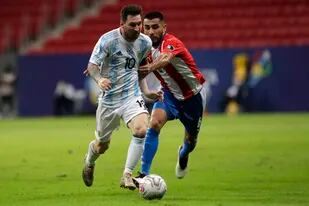 Lionel Messi y el paraguayo Junior Alonso pelean por el balón durante un partido de la última Copa América, en el estadio Nacional de Brasilia. esa noche, la selección ganó por 1-0