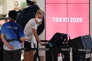Una integrante de la delegación británica llega al aeropuerto de Tokio; la situación, cada vez más complicada en la sede de los Juegos