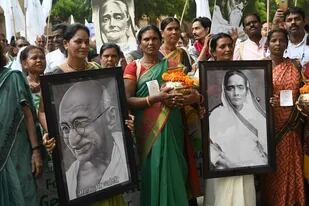 Activistas llevan fotos de Mahatma Gandhi y su esposa, Kasturba Gandhi por el 150 aniversario de su nacimiento en una marcha por la paz