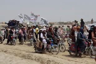 En esta fotografía de archivo del 14 de julio de 2021, los partidarios de los talibanes llevan sus banderas blancas distintivas después de que los talibanes dijeron que tomaron la ciudad fronteriza afgana de Spin Boldaka frente a la ciudad de Chaman, Pakistán