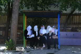 Mujeres afganas esperando el tranposrte para ir a clases en Herat, el 17 de agosto de 2021