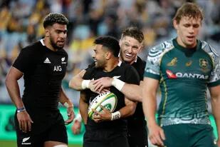 El neozelandés Richie Mounga, segundo a la izquierda, es felicitado por su compañero Beauden Barrett después de anotar el tercer try de su equipo durante la prueba de rugby de Bledisloe entre los All Blacks y los Wallabies en el Stadium Australia,